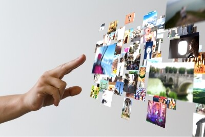a hand interacts with a cloud of various digital images