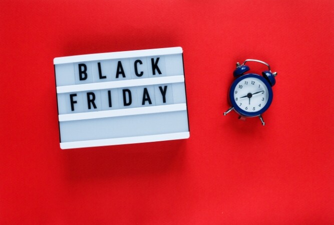 a letter board with 'black friday' on it lays next to an alarm clock