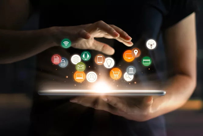 app logos hovering over a tablet in a person's hand